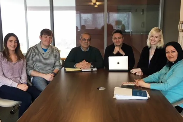 Faculty and students sitting around a table