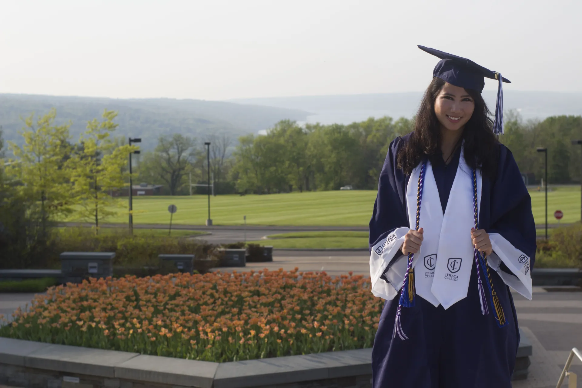 A young woman wearing graduation robes and a mortarboard