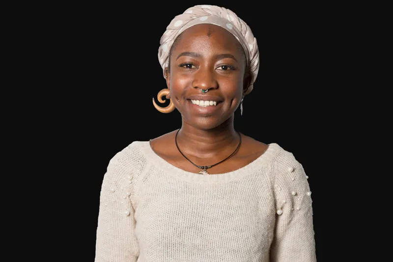 A young African woman facing forward and smiling.