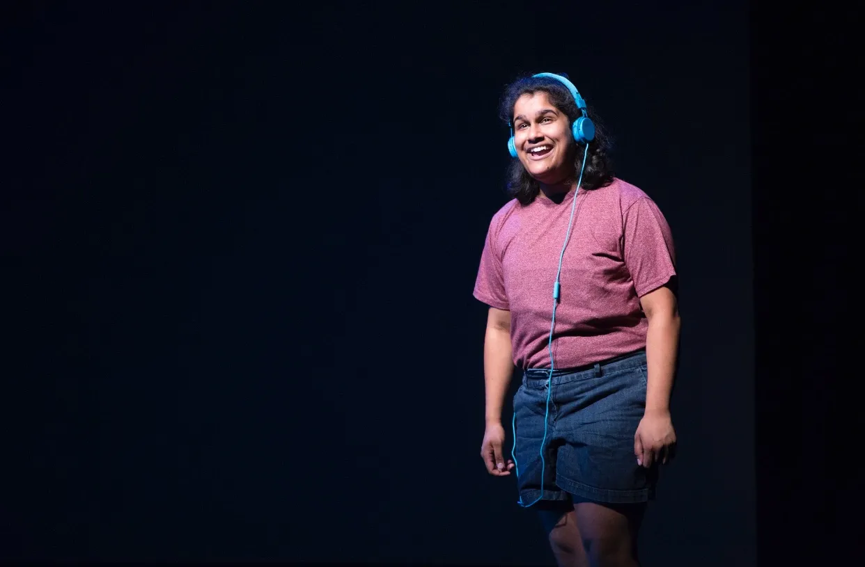 A person wearing headphones on a dark stage