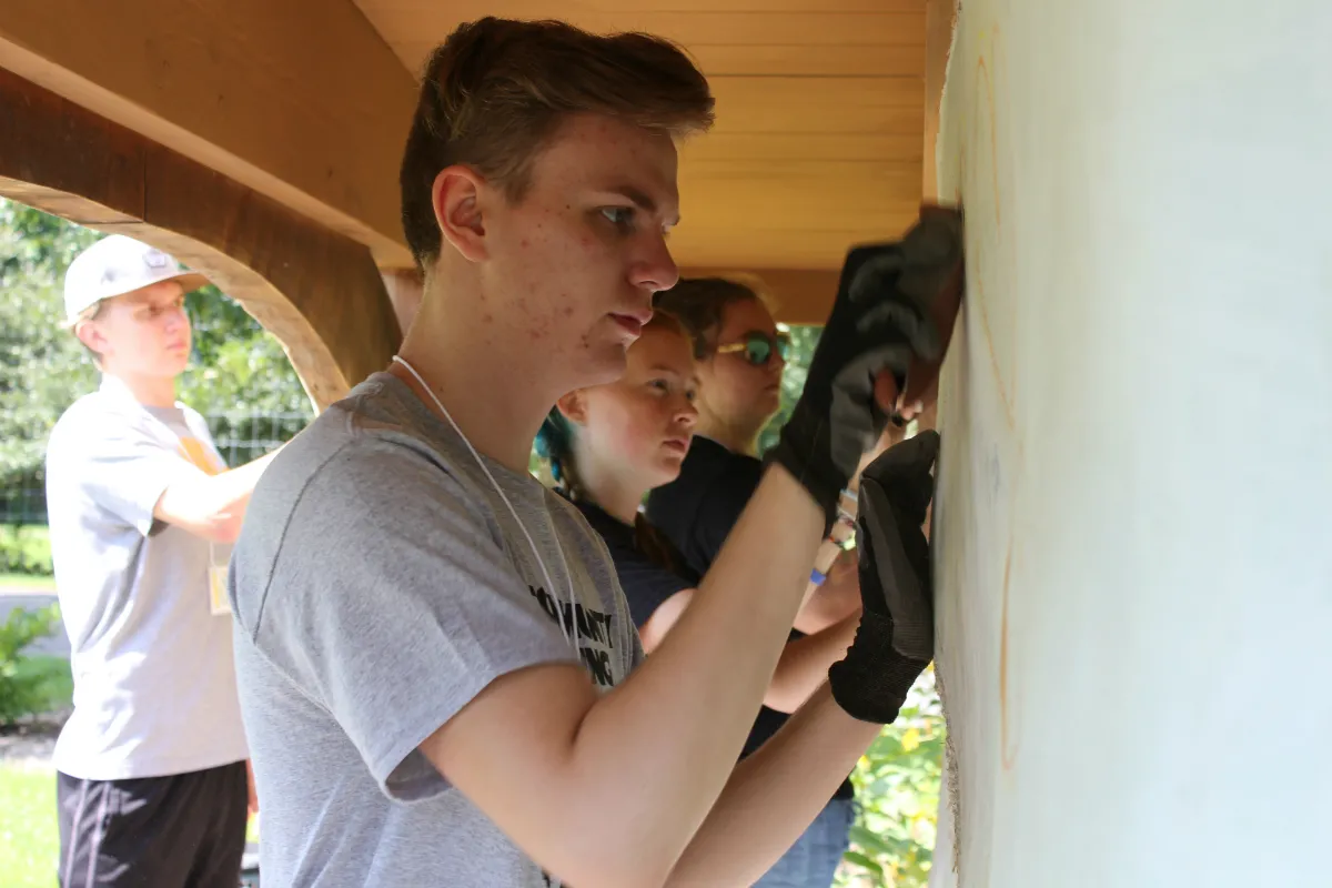Young people scrubbing a wall