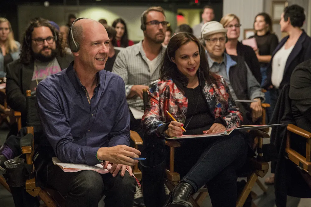 A man and a woman sitting in director's chairs