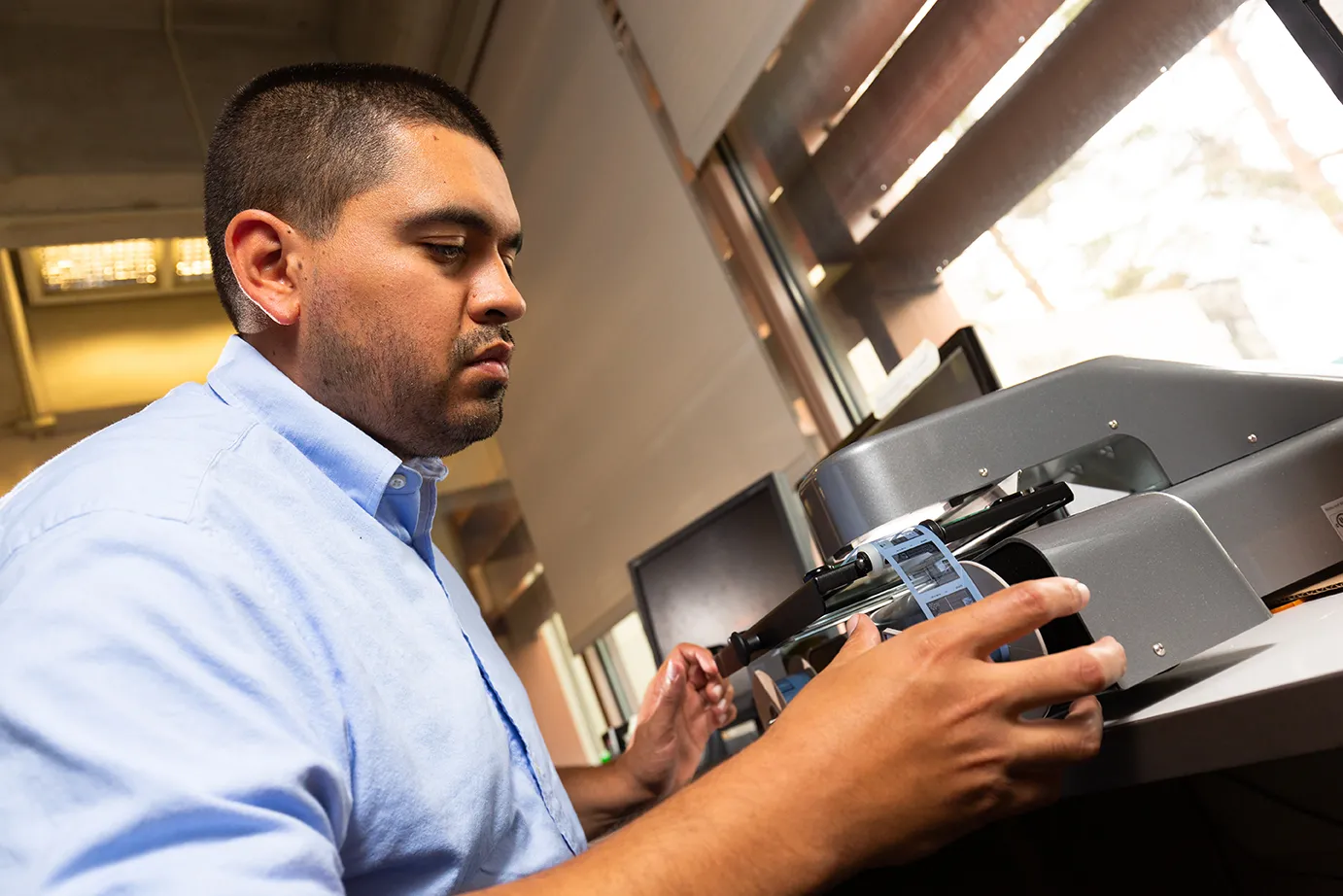 Gustavo Licón using a microfilm reader