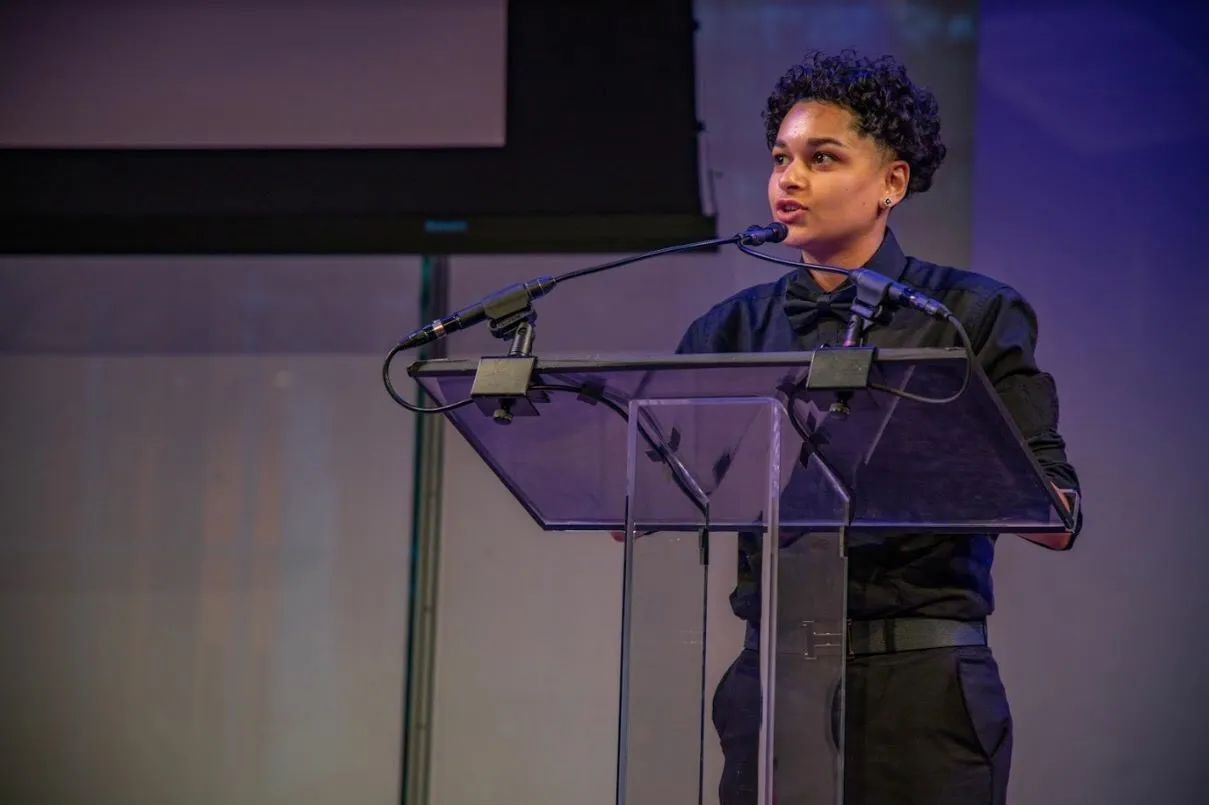 A young man speaking at a lecturn