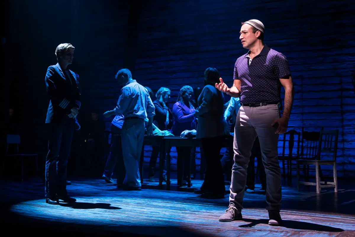 A man on stage wearing a Muslim prayer cap