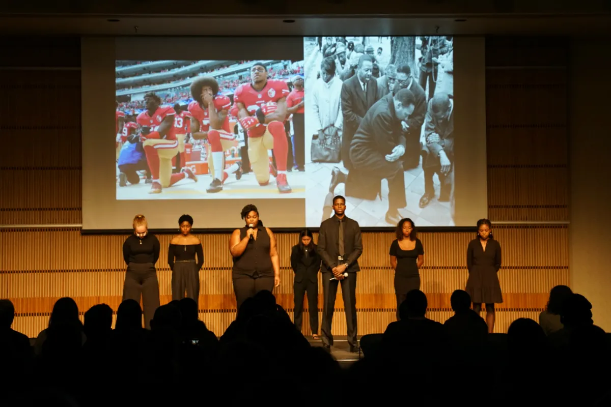 Young people wearing black standing on stage