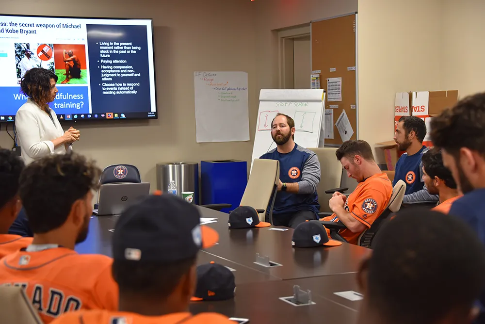 Jesse Michel speaks to baseball players in a classroom