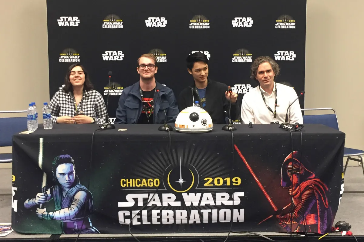 Three men and one woman sitting at a table