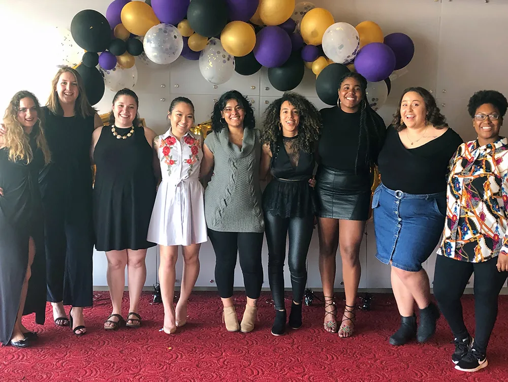 group of women standing in front of balloons