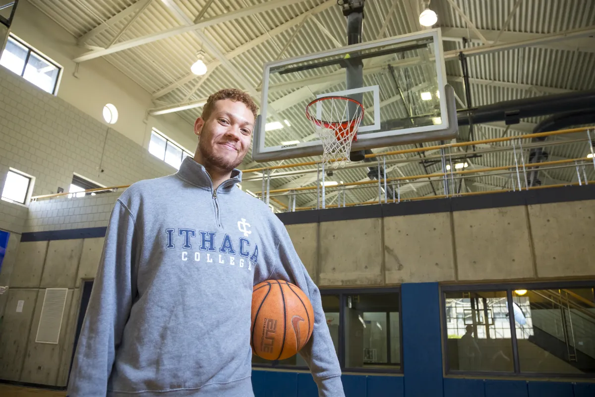 A man standing with a basketball on a basketball court
