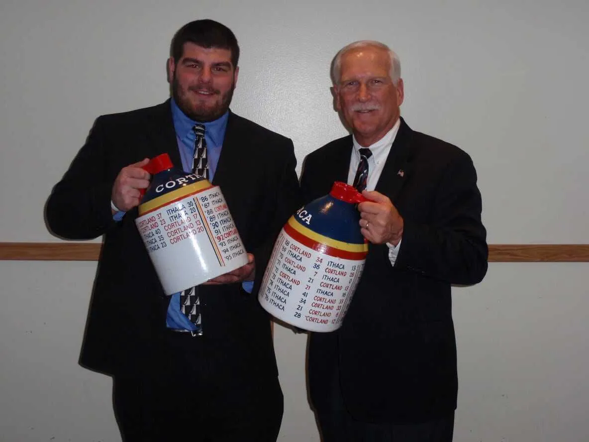 Two men holding the Cortaca Jugs 