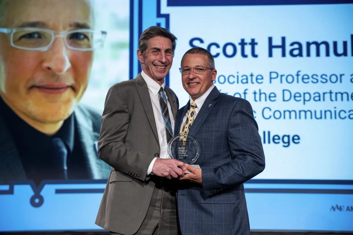Two men holding an award