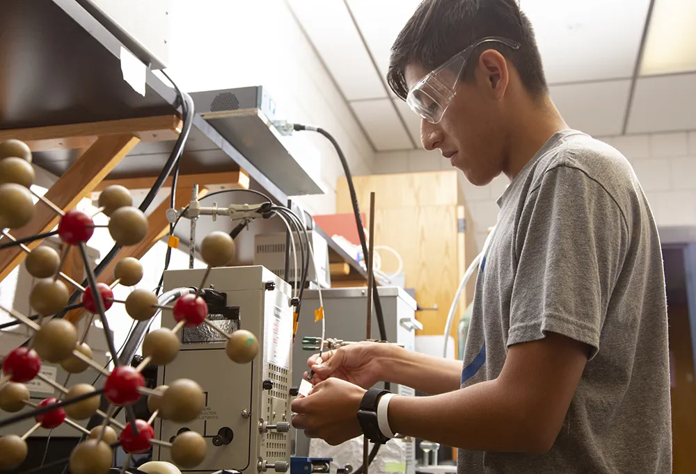 student working with scientific equipment in a lab