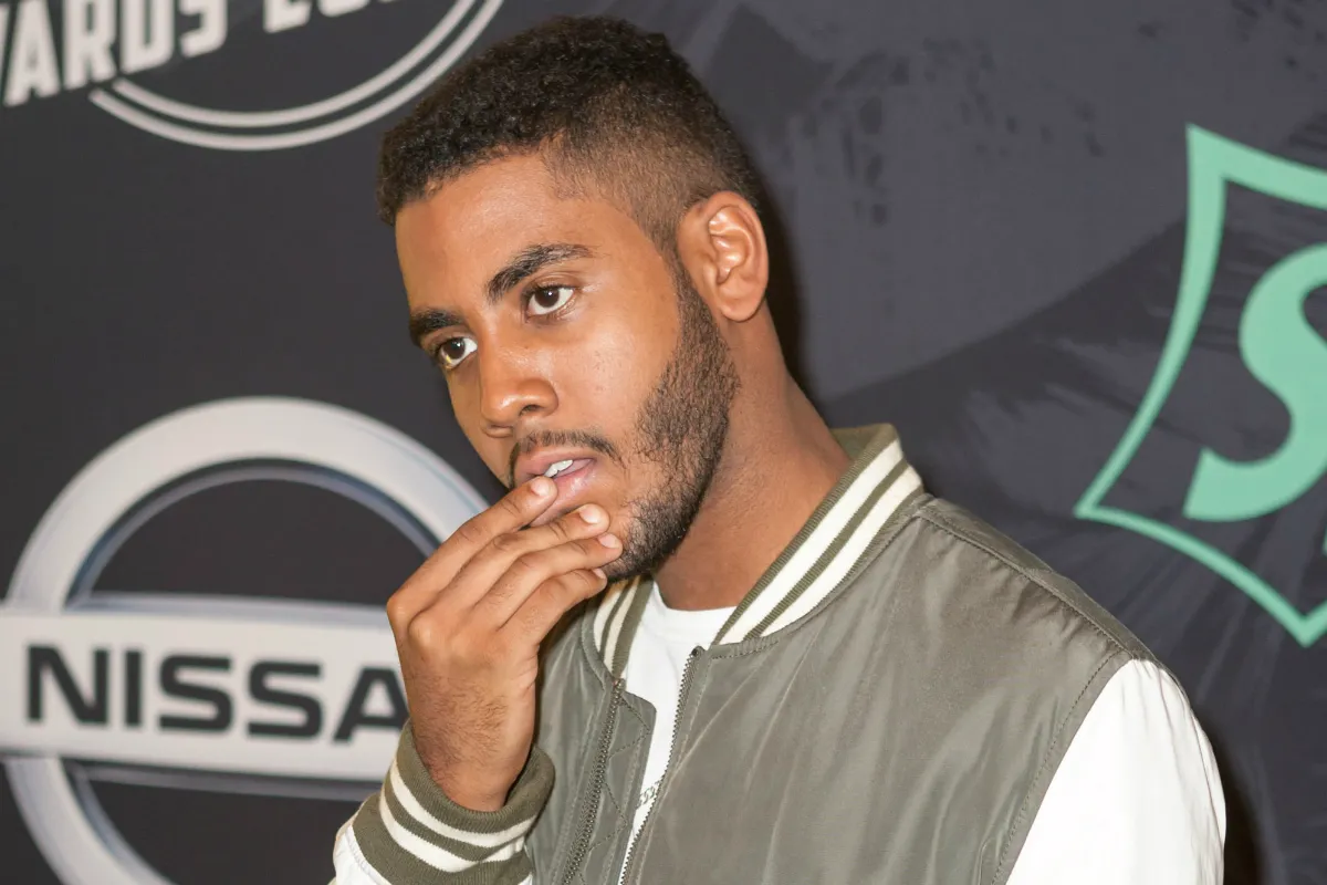 A young man posing in front of a backdrop