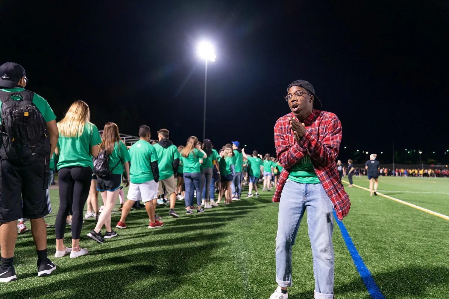 A young man clapping for a line of people