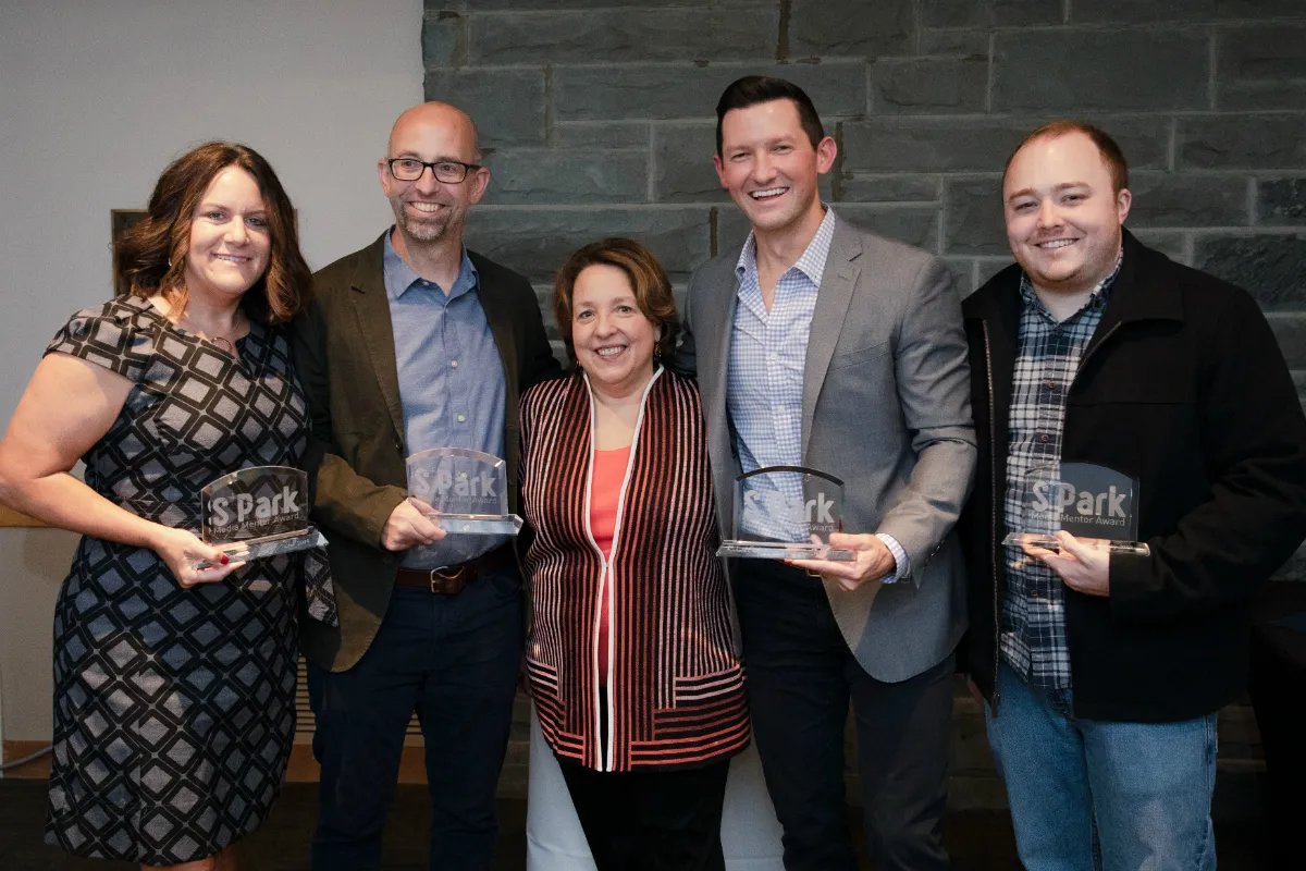 A group of men and women holding awards