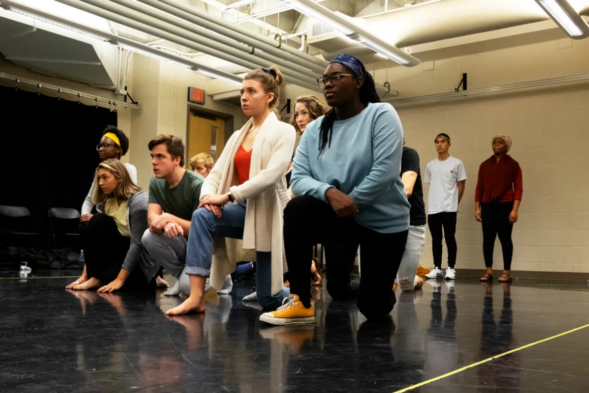 Young people kneeling in a rehearsal space