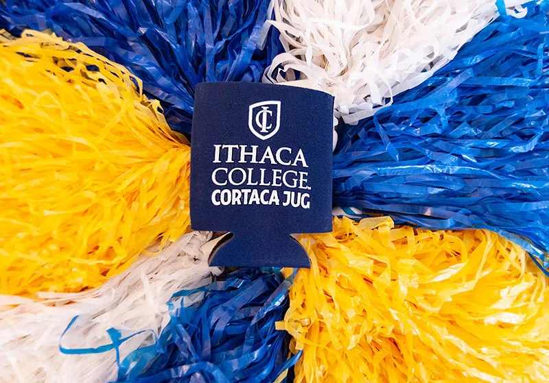 Cortaca Koozie on blue, white and yellow pom-poms