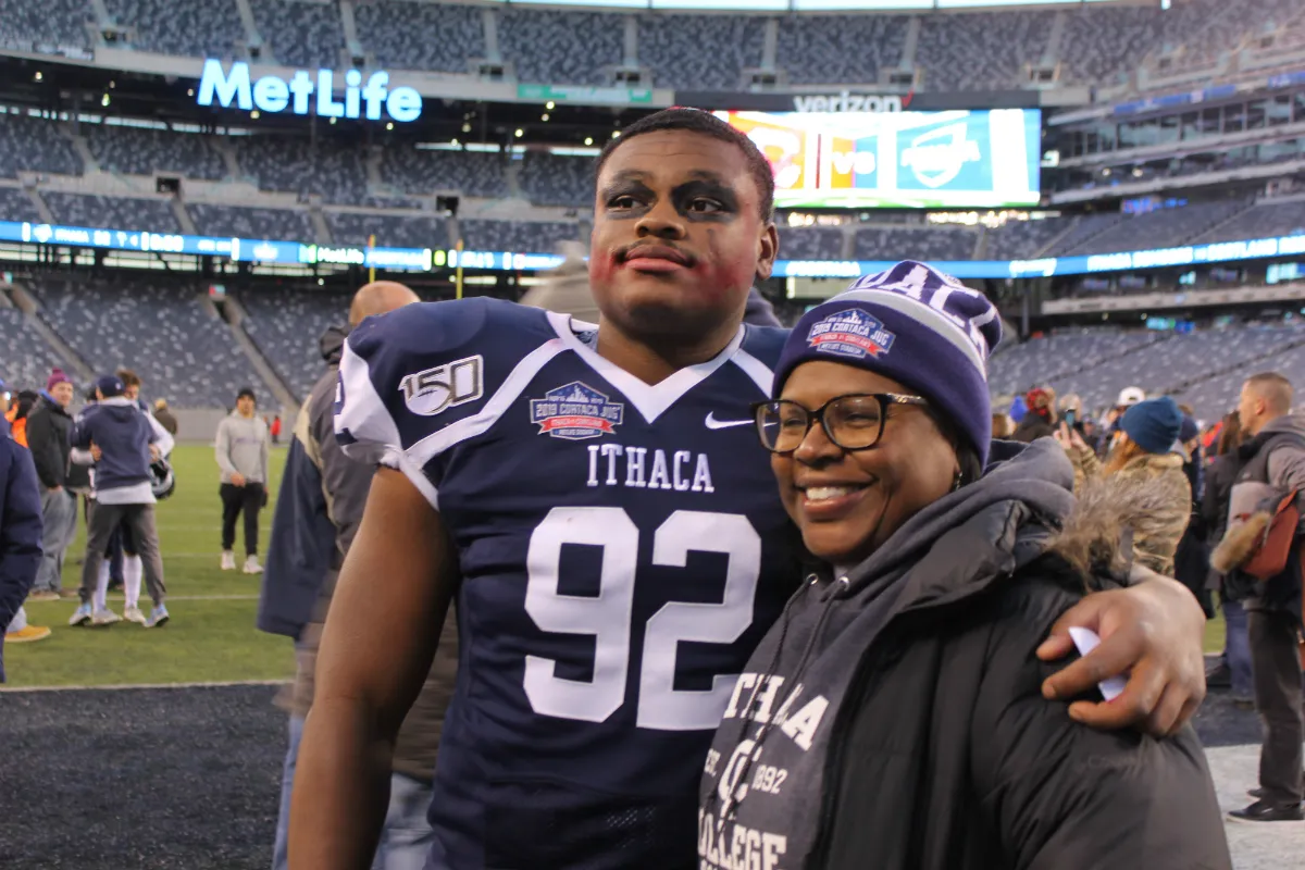 A football player with his arm around an older woman