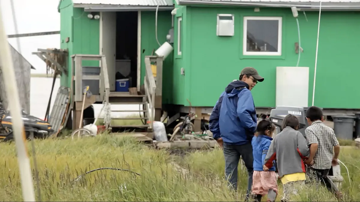man and children walking toward house