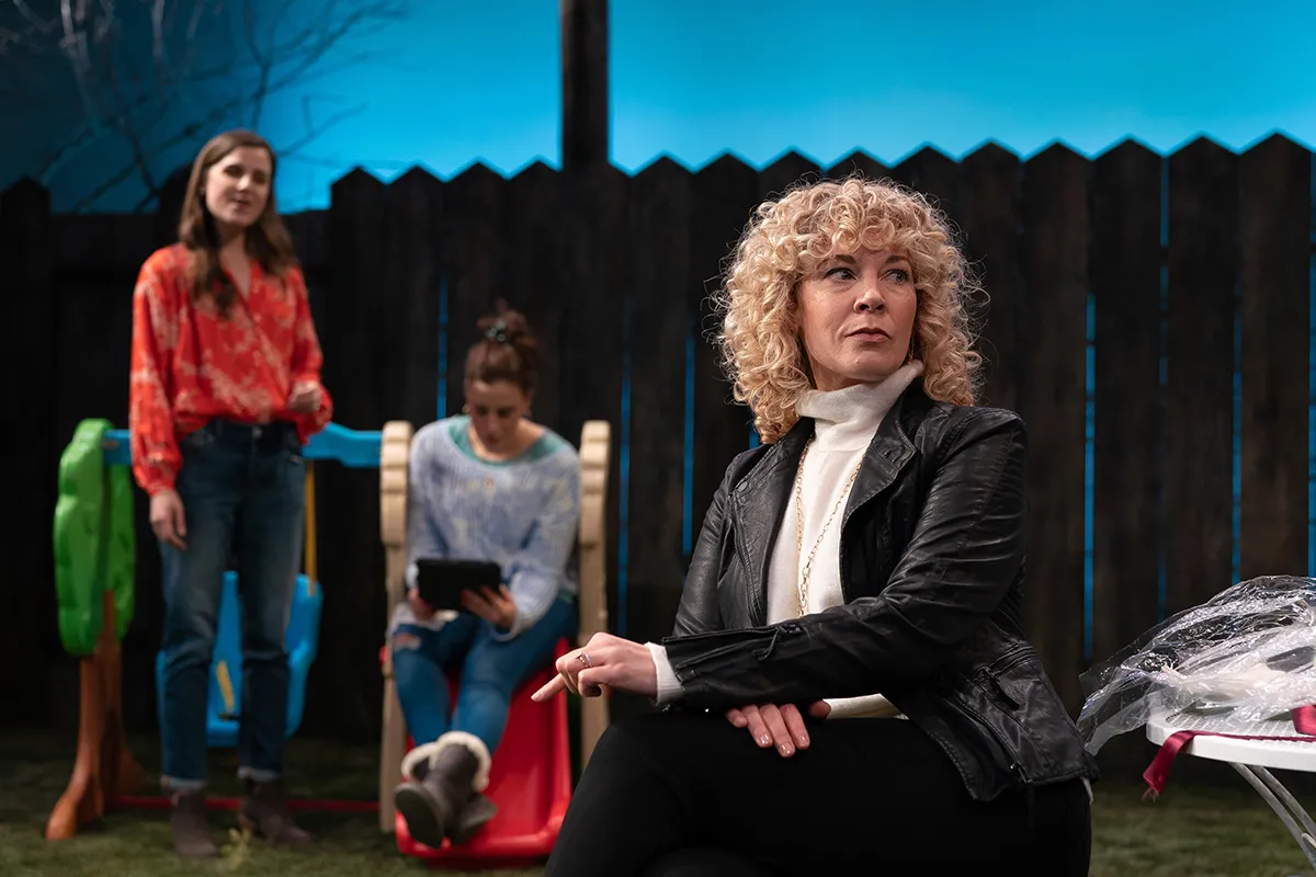 woman sitting in lawn chair while other women look on