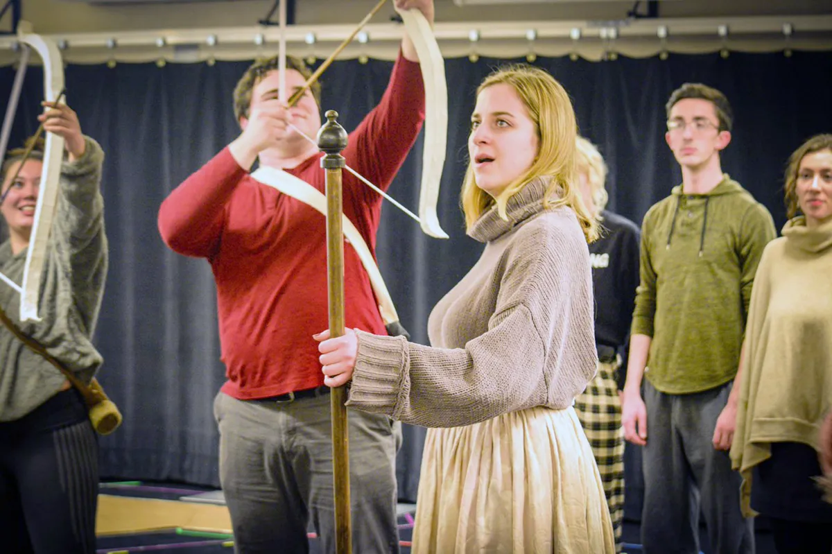 woman holding a bow and arrow on stage