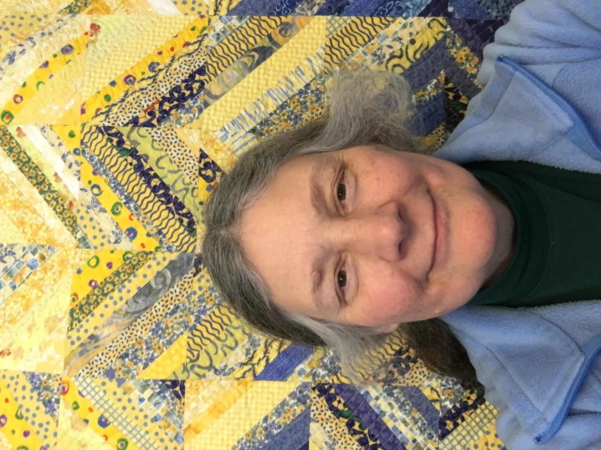 Photo of Bridget in front of yellow and blue quilt