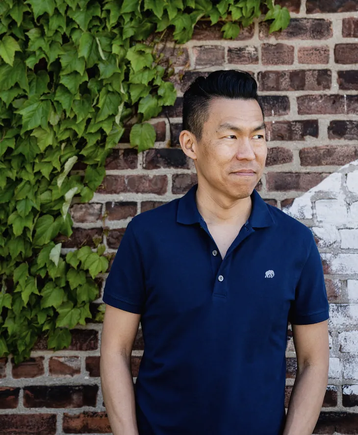 Jack Wang standing against brick wall