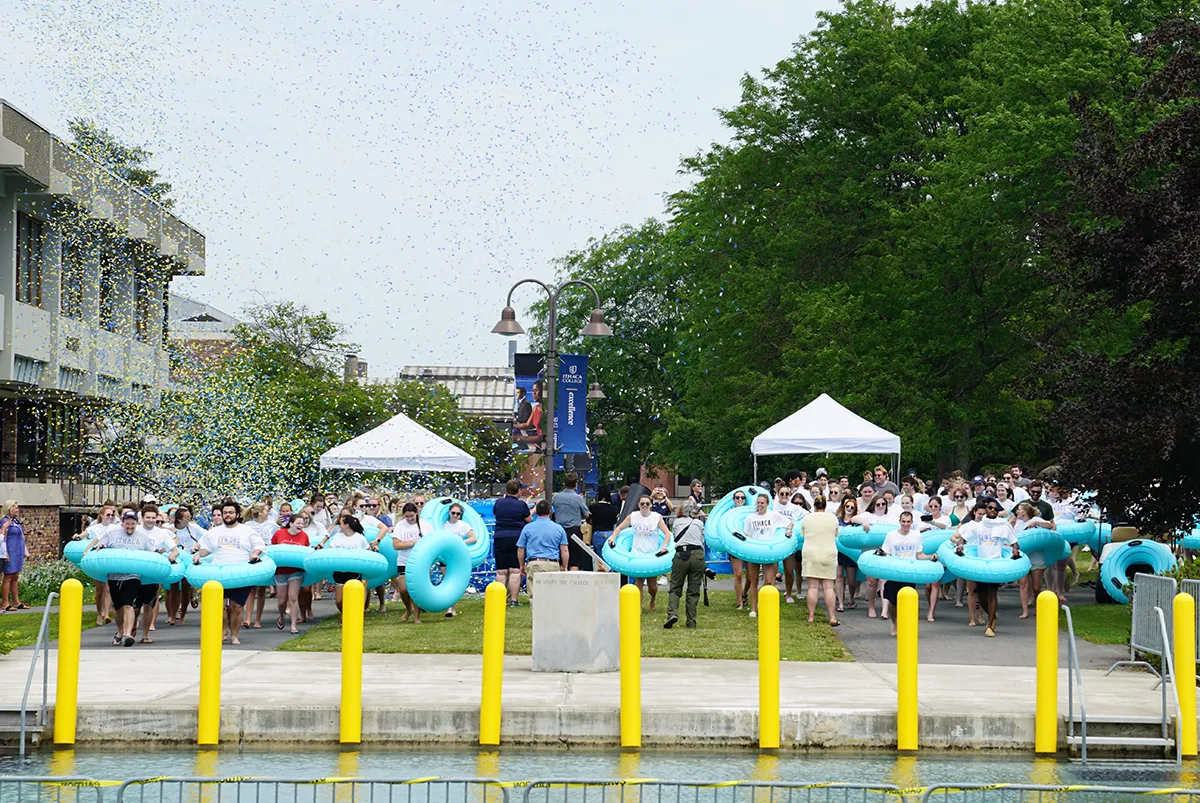 Students in inner tubes running toward Dillingham fountain.