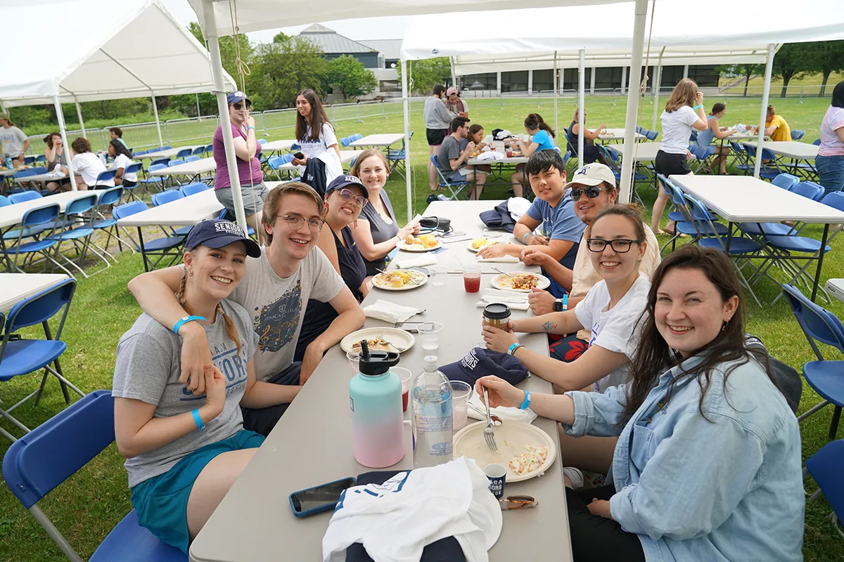 Alumni sitting at a picnic table on the IC Quad
