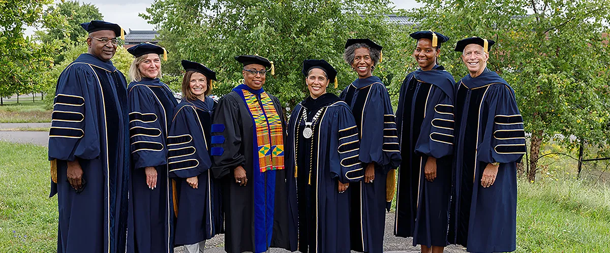 Members of the Board of Trustees standing outside with the president and provost