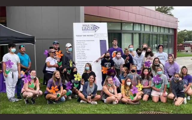 Group of people standing in front of a sign
