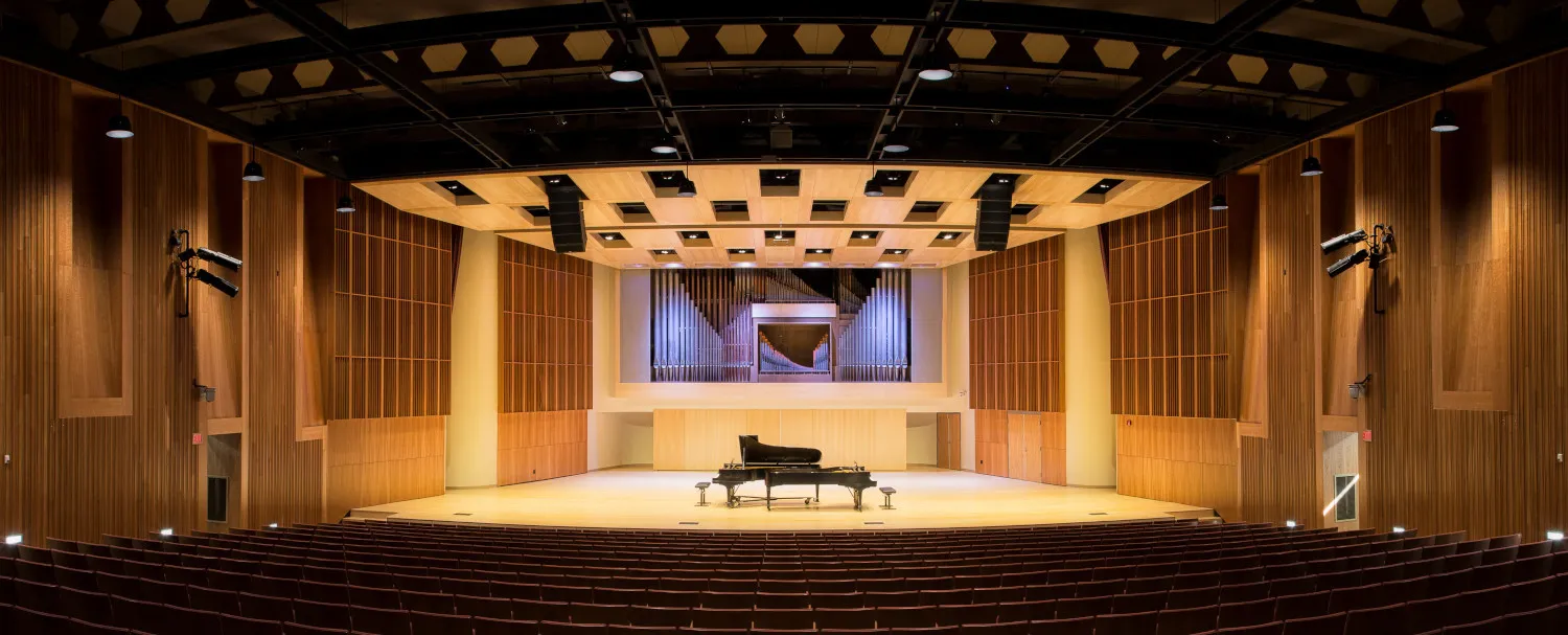 A well-lit stage with pianos in the center
