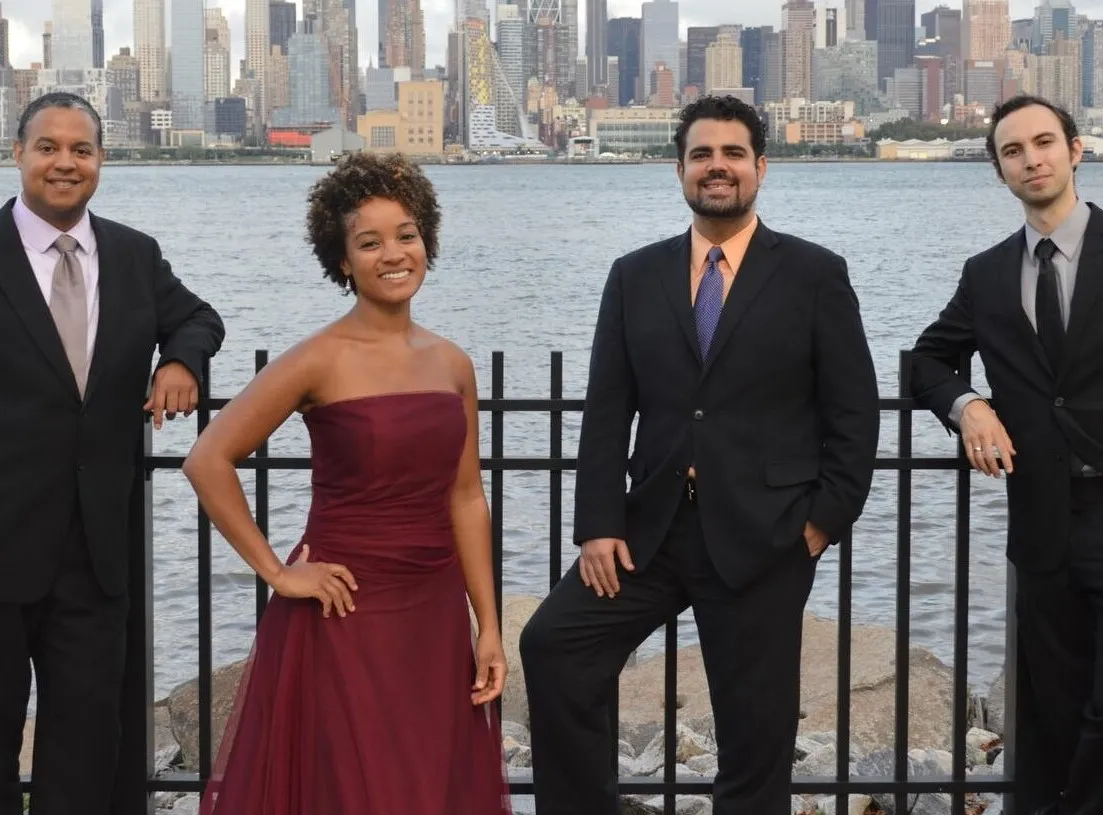 four people standing with city skyline