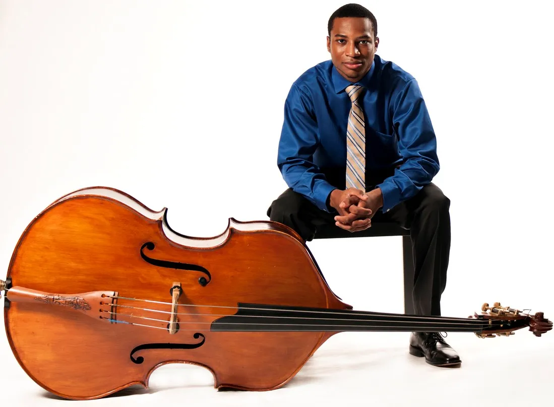 man sitting with bass on its side