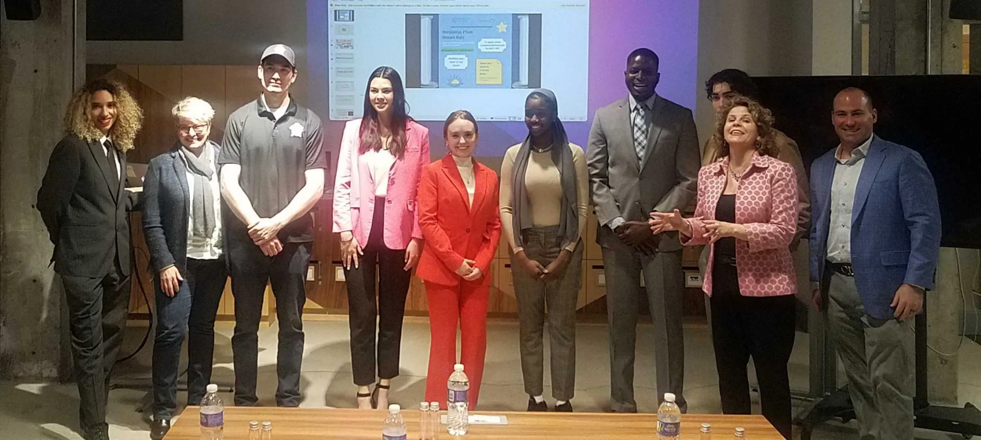 Students posing in front of a screen
