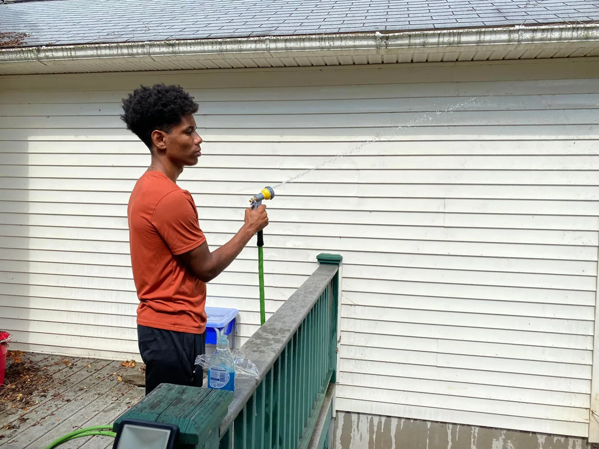 Student spraying a building with a hose