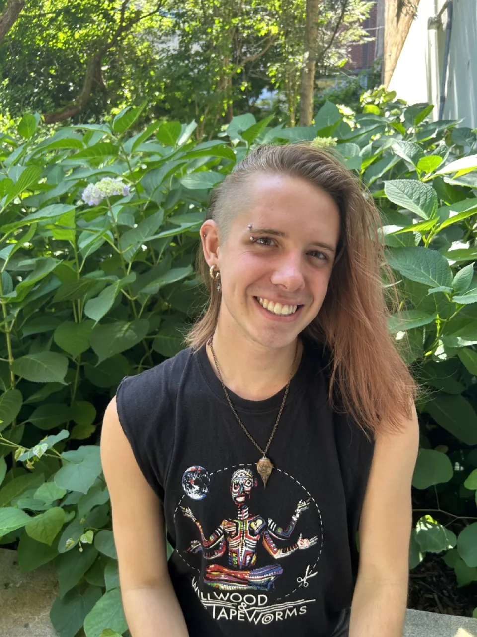 person sitting in front of a tree and smiling