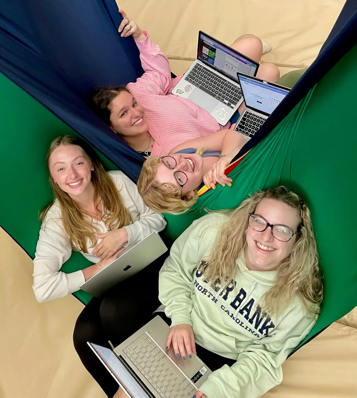 Students experiencing proprioception in lycra swing while completing classwork.