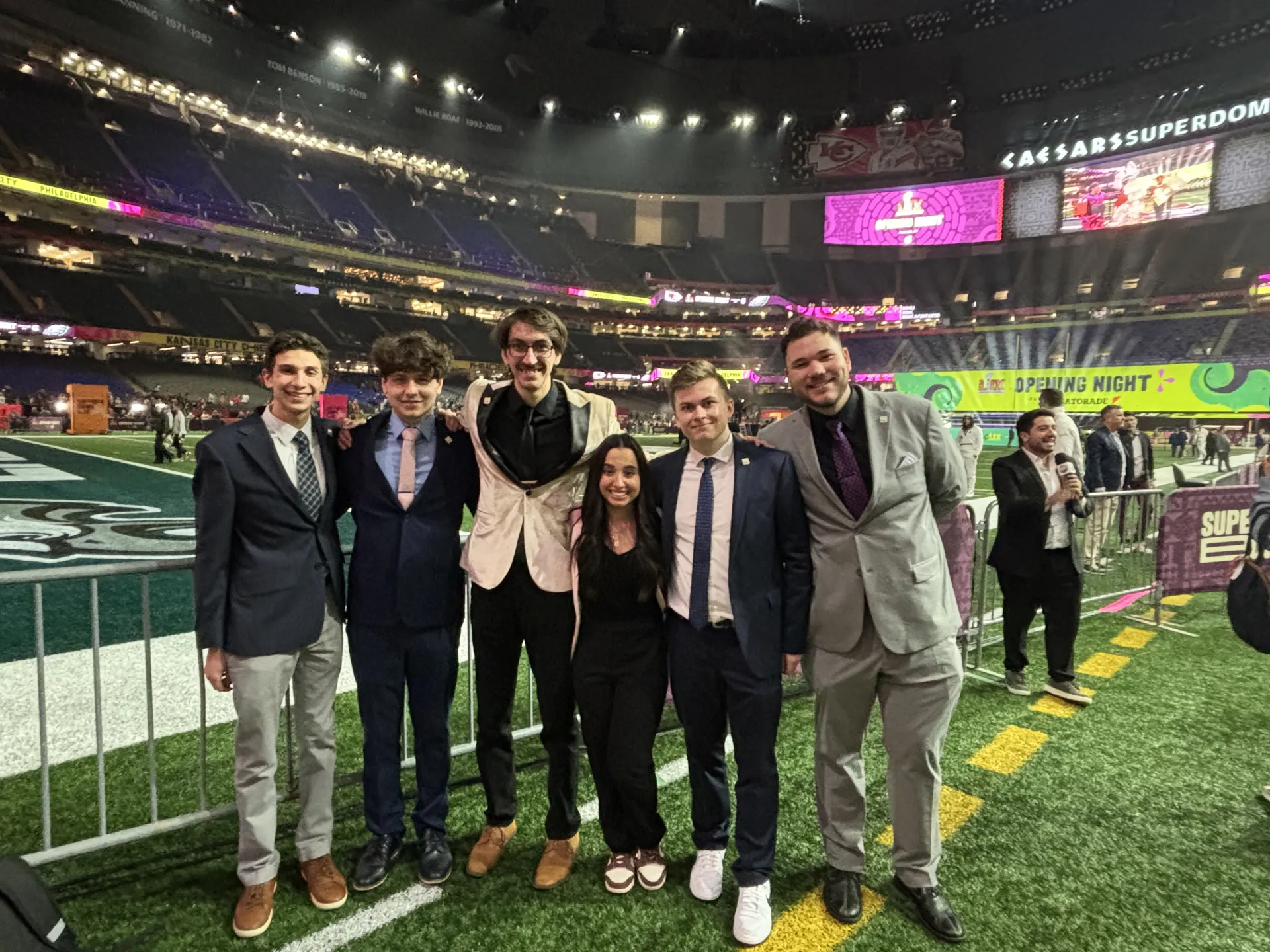 A group photo of college students on an NFL field