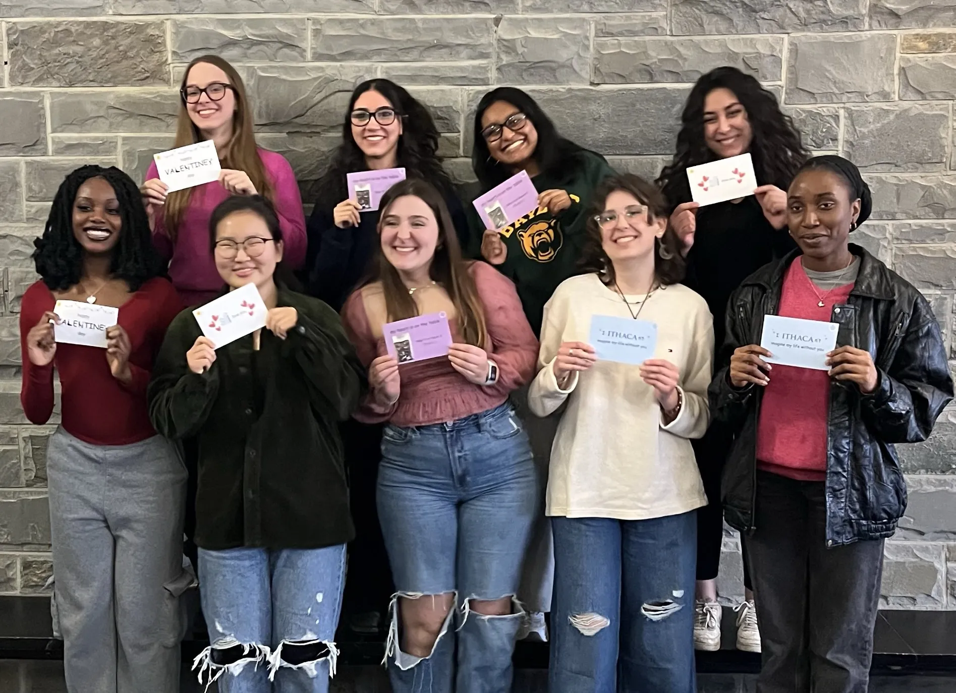 Group photo of nine women college students holding up messages written on cards