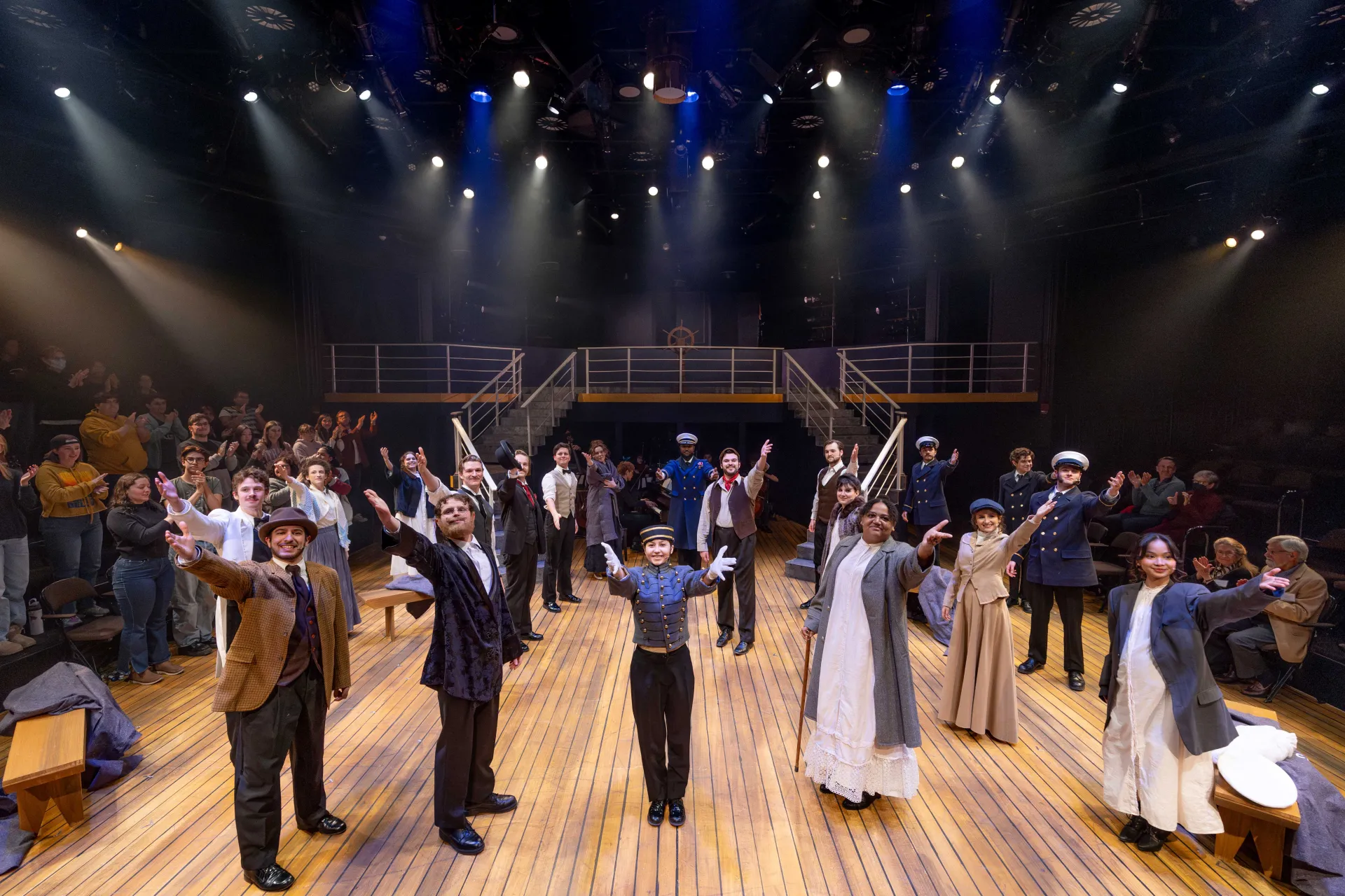 Performers on stage with raised arms.