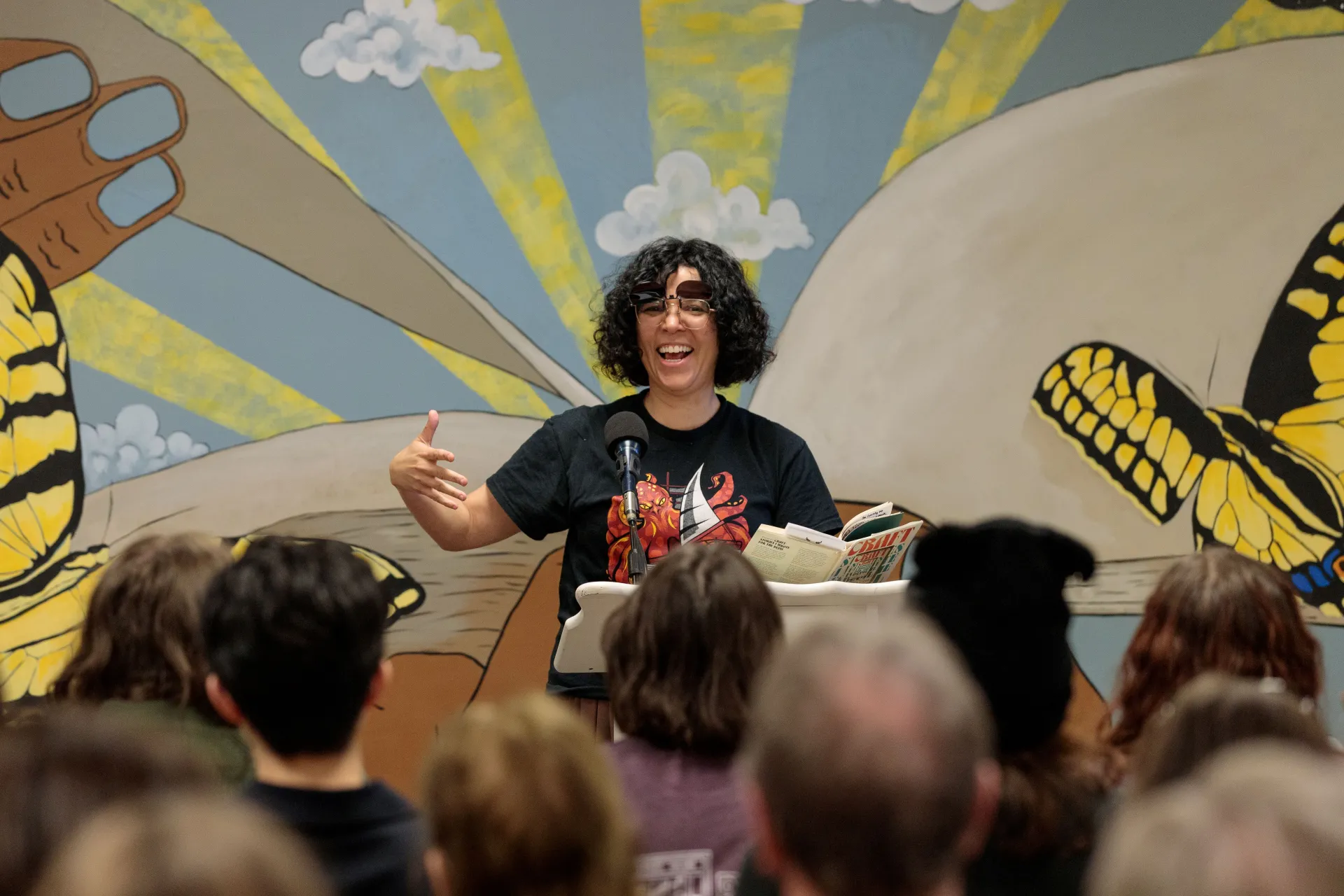 An author reads at a podium. 