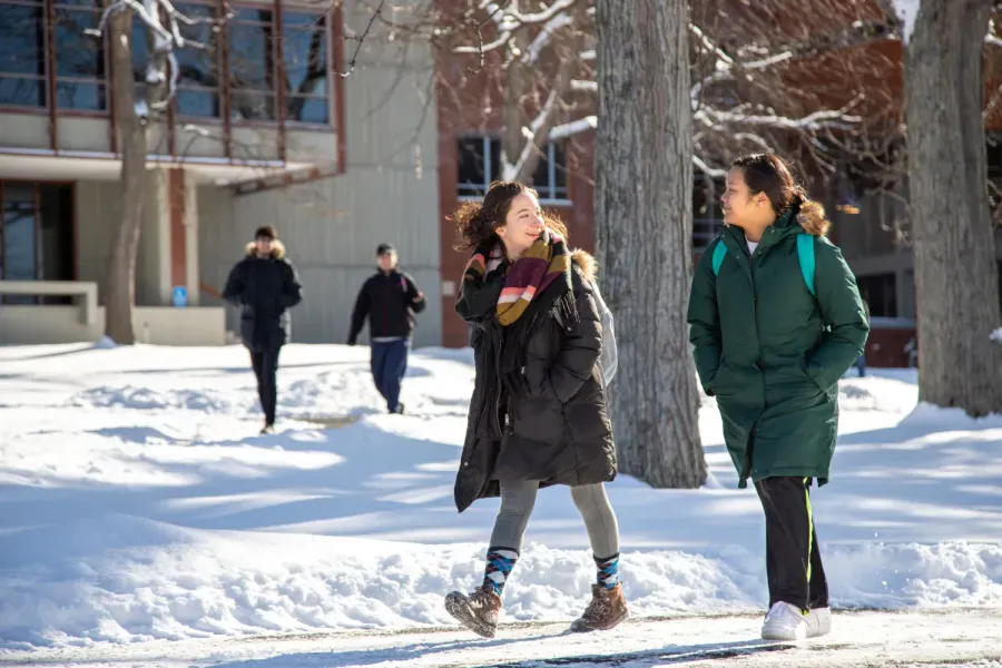 Students walking across the snowy campus.