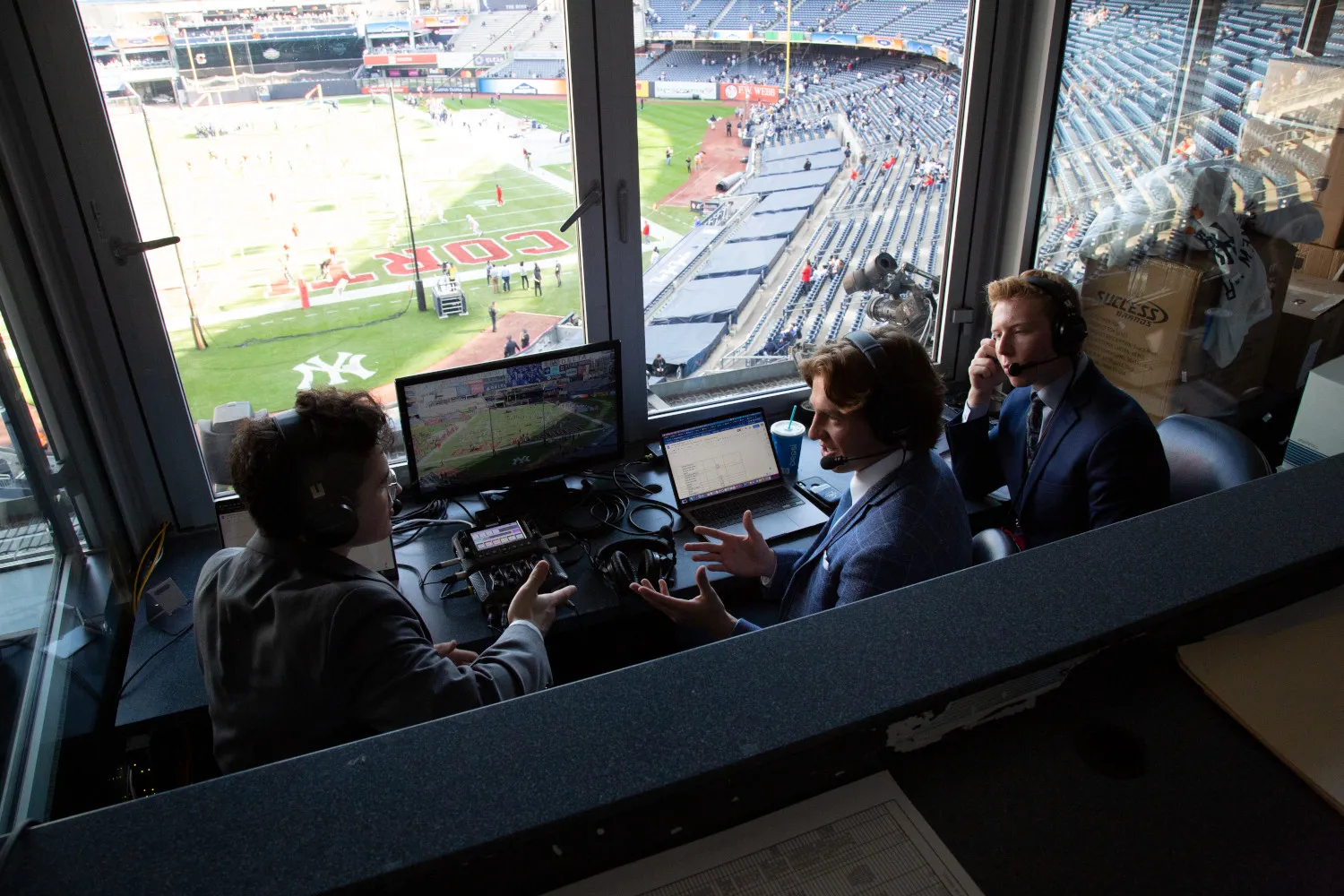 Student journalists works "the box" of a football match