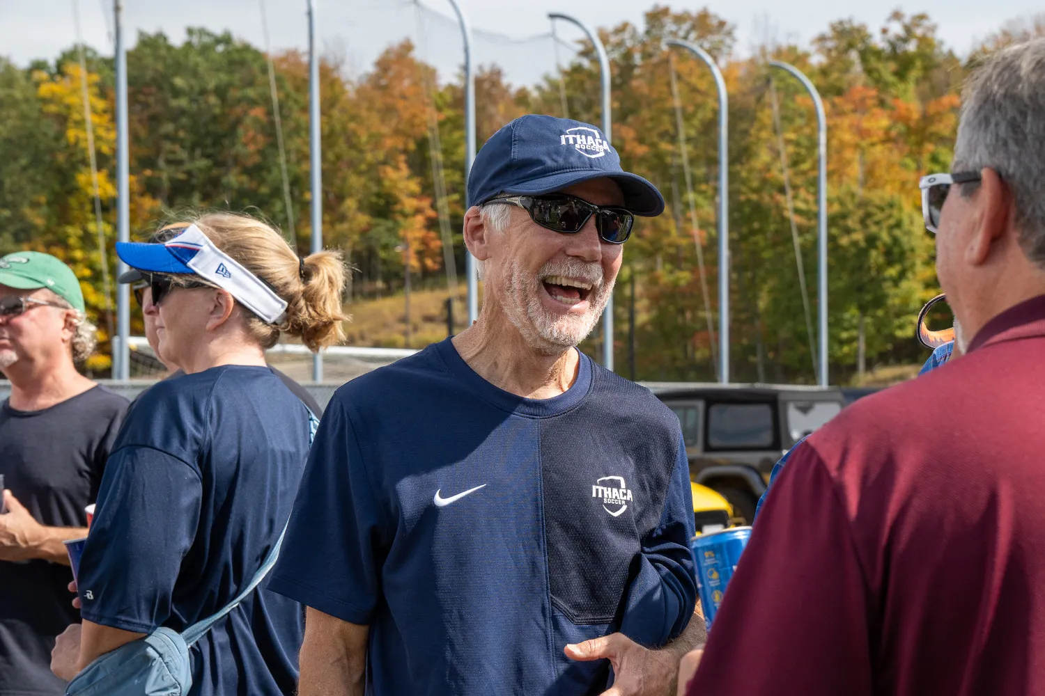 A man smiles and talks at a tailgate party.