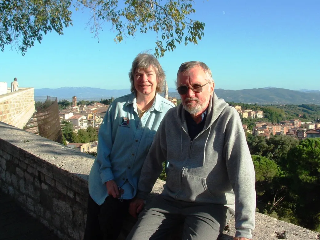 A man and woman on vacation in a medieval Italian city.