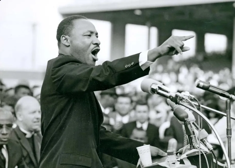 Image of MLK at podium during march on Washington speech pointing to the crowd.