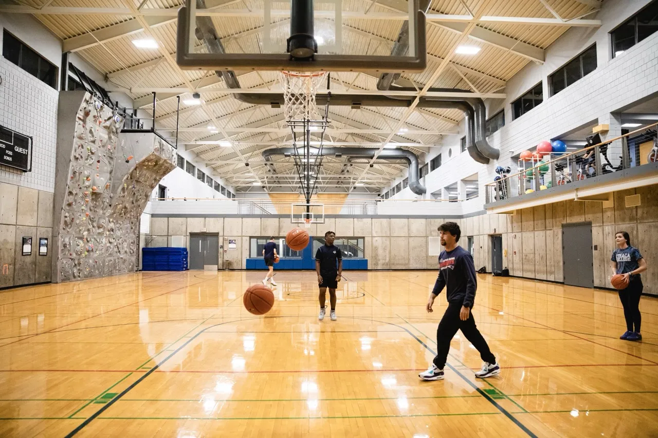 Students engaging in a recreational pickup basketball game within the Wellness Center at Ithaca College