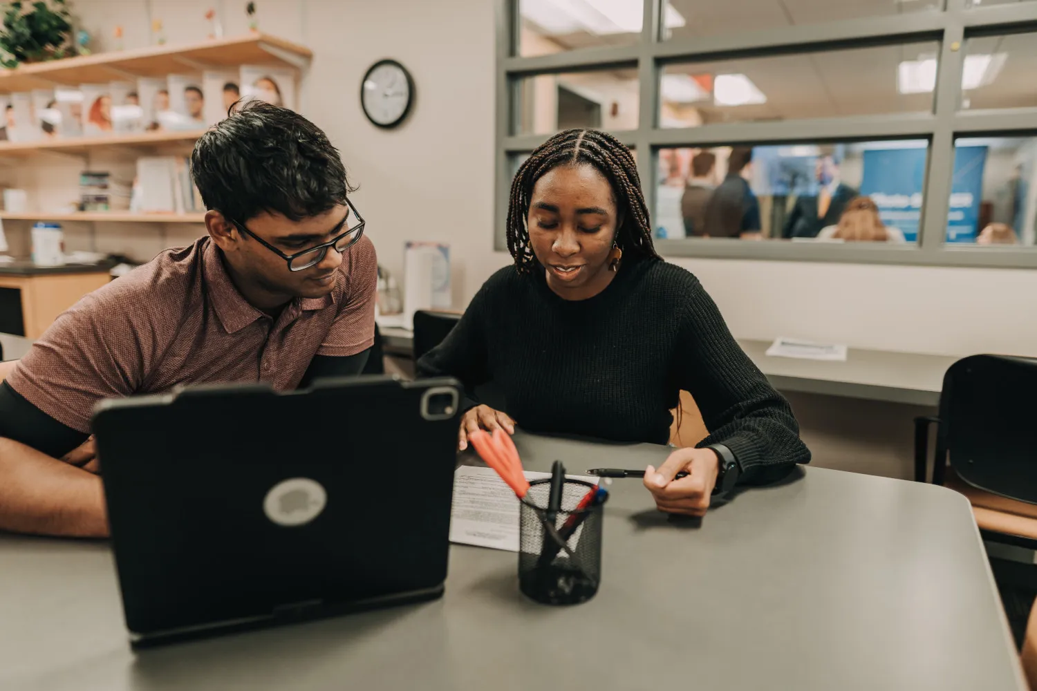 A college student works with a career specialist at a computer.